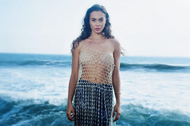 Jannita parada en la orilla del mar