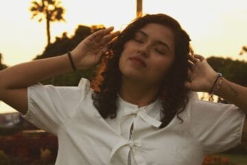 Leslie Baltazar con blusa blanca en el ocaso