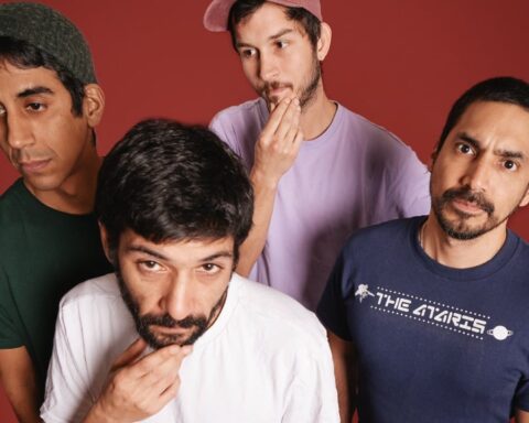 Luis Guzmán posando con un fondo rojo