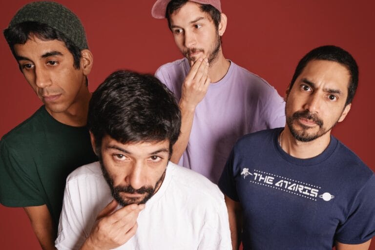 Luis Guzmán posando con un fondo rojo