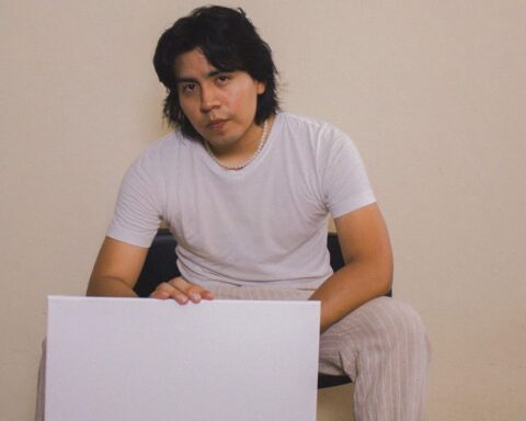 Mial con polo blanco sosteniendo un cartel blanco