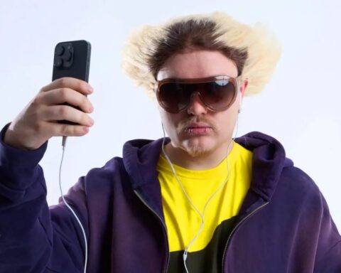 Rusowsky sosteniendo un celular con lentes de sol