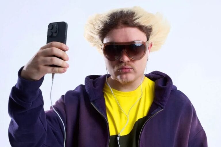 Rusowsky sosteniendo un celular con lentes de sol