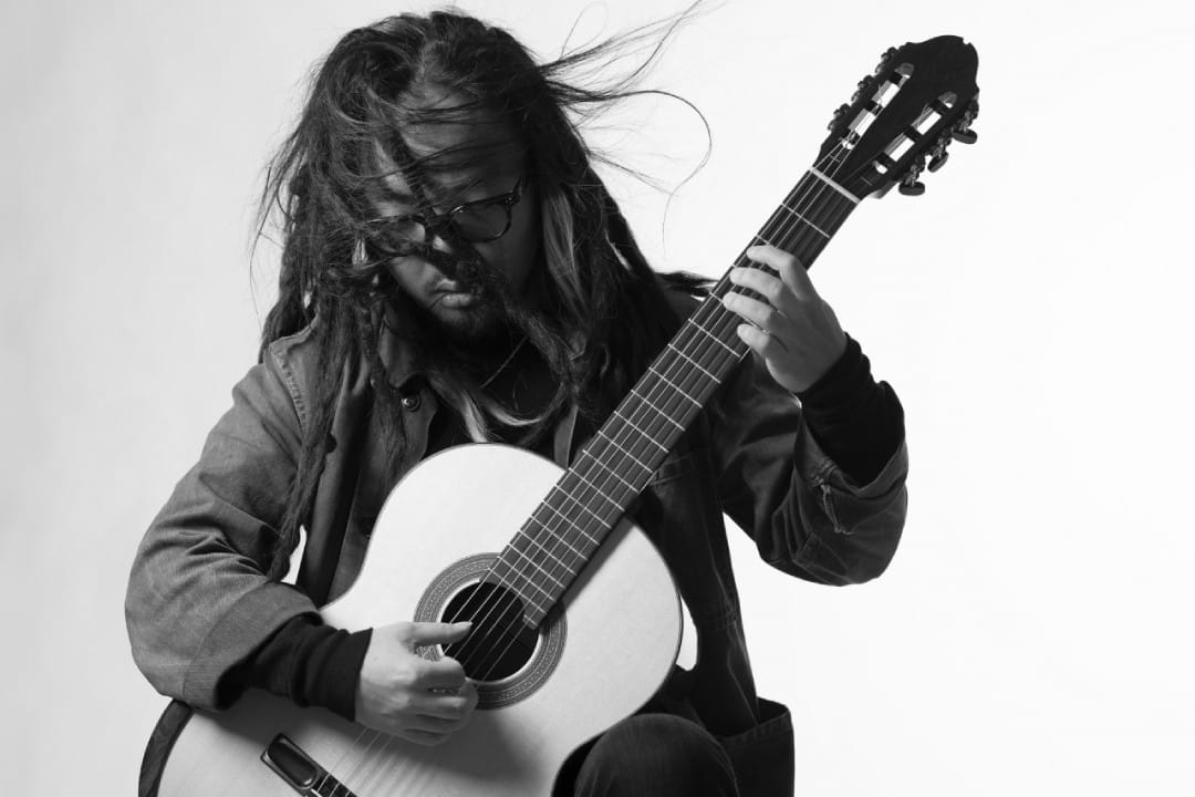 Shin Sasakubo interpretando con guitarra en mano