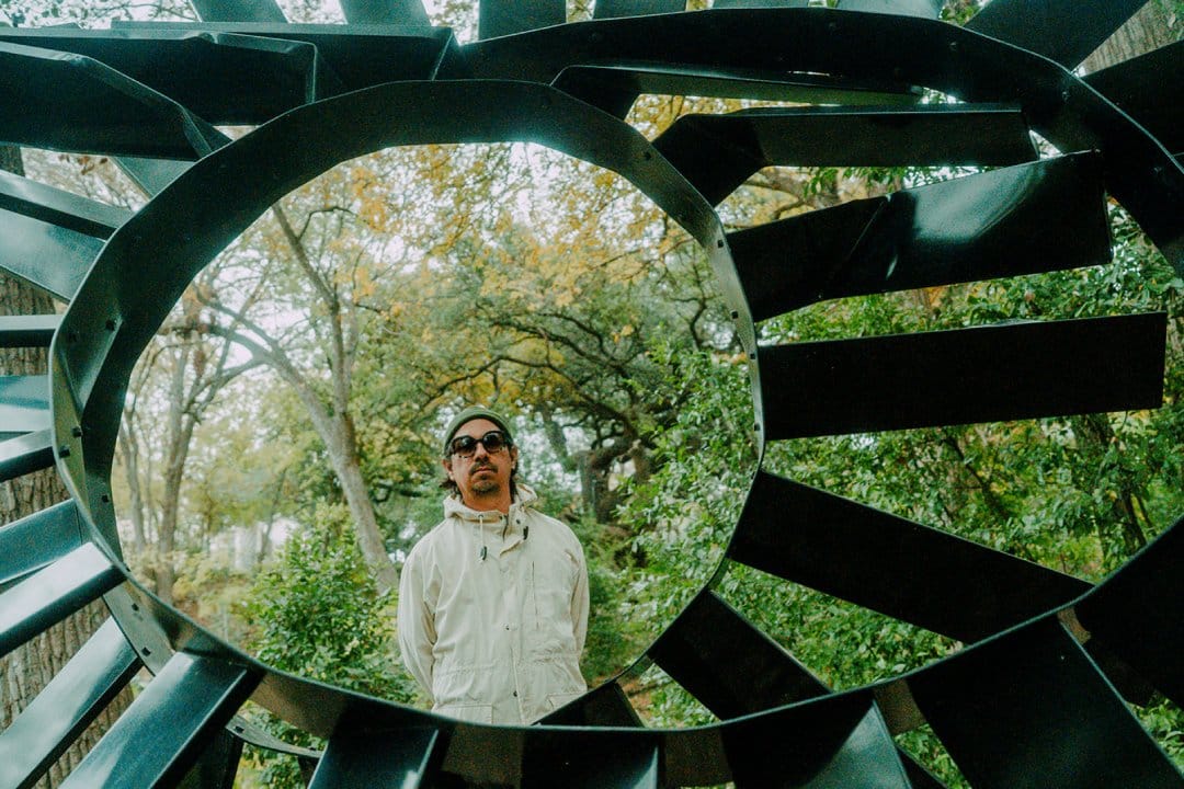 Adrián Quesada posando en un monumento con forma espiral