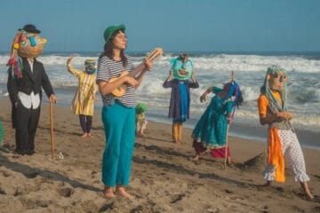Alma Libé en la playa tocando el charango