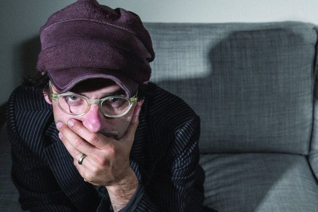 Alec de Clap Your Hands Say Yeah sentado tapándose la boca