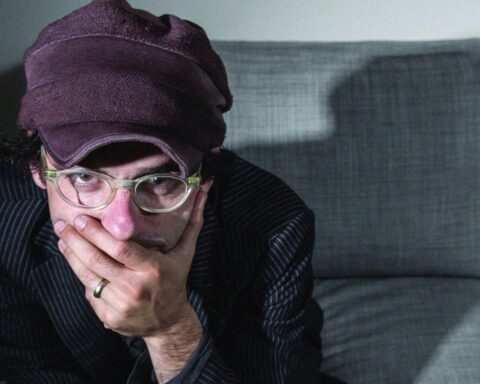 Alec de Clap Your Hands Say Yeah sentado tapándose la boca