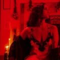 Gala Brie sentada con un traje rojo