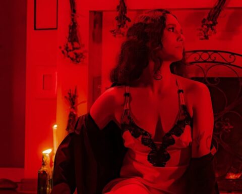 Gala Brie sentada con un traje rojo