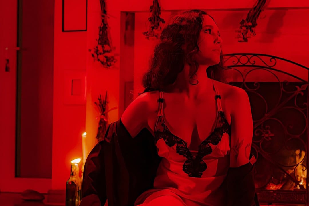 Gala Brie sentada con un traje rojo