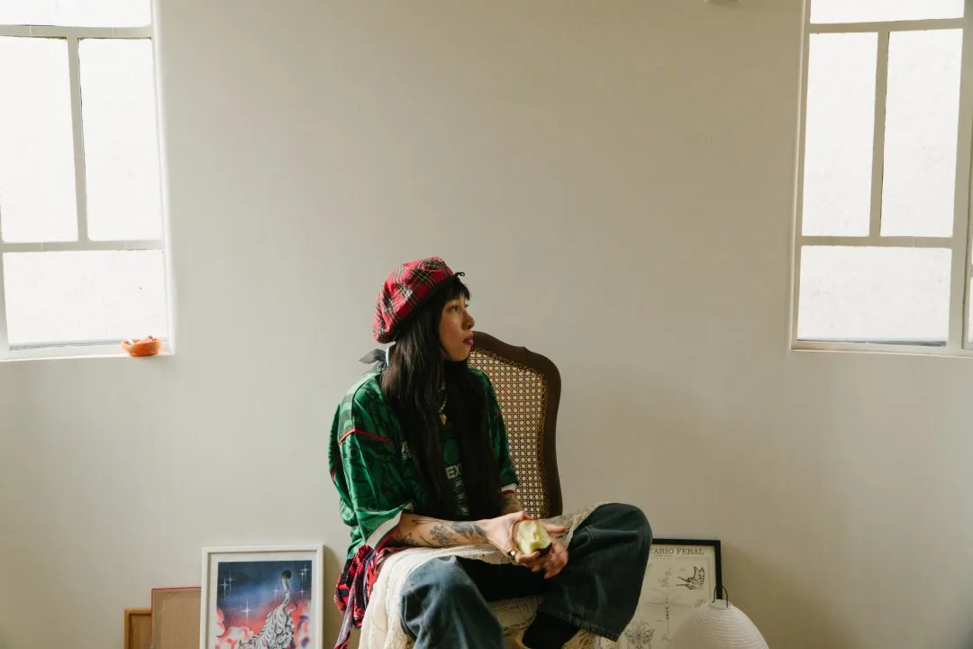 Karina Galicia sentada con un polo verde