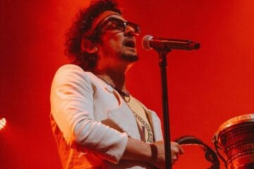 León Larregui sobre el escenario con traje blanco
