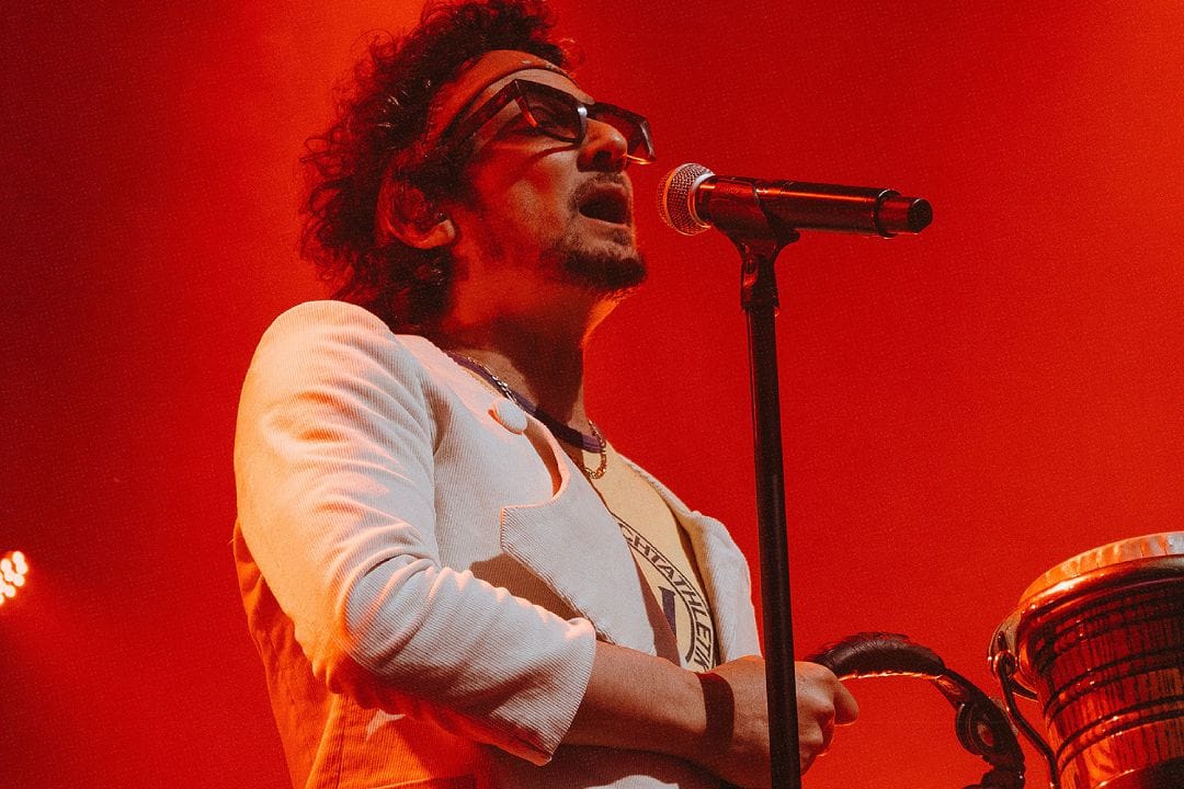 León Larregui sobre el escenario con traje blanco