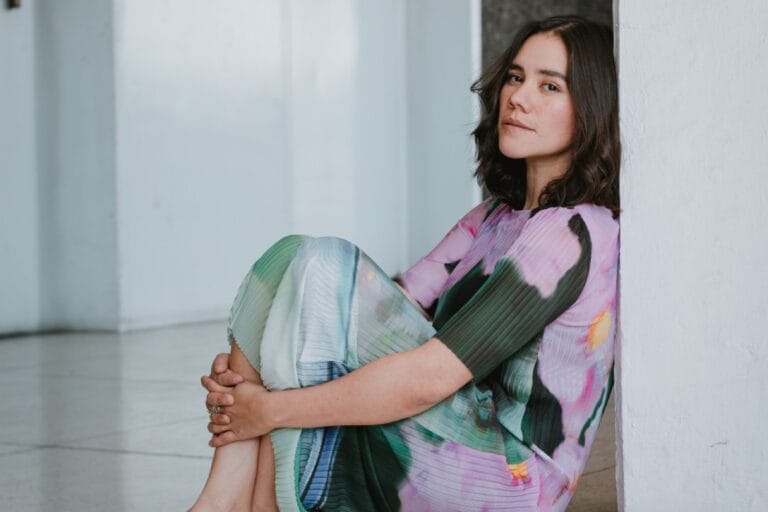Pahua sentada dando la espalda a una pared