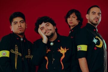 Plastical People con trajes negros y fondo rojo