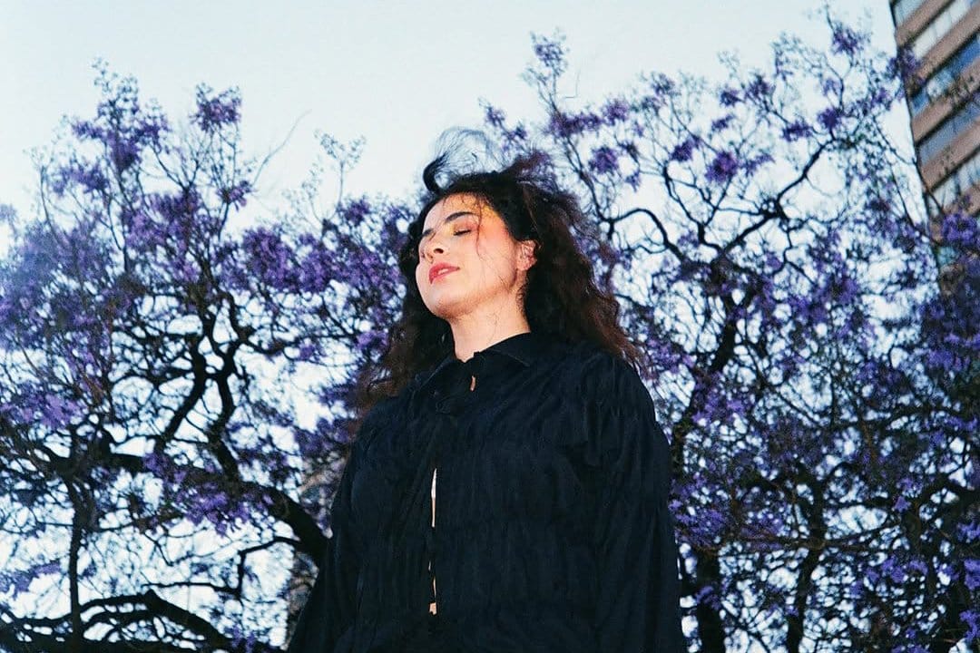 Silvana Estrada posando con un árbol detrás