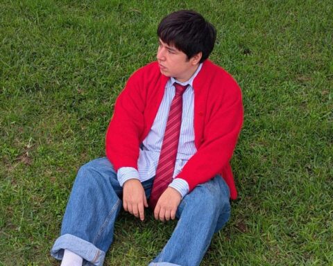 Andoni con chompa roja sentado sobre el césped