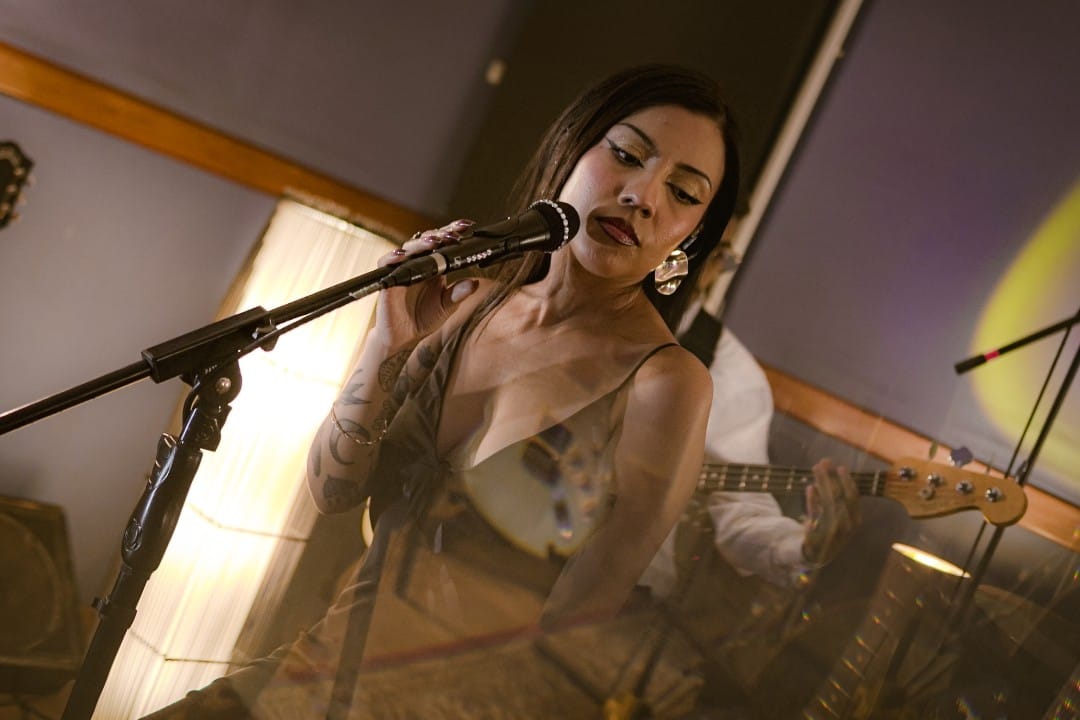 Diana Flores posando con el micrófono en el estudio