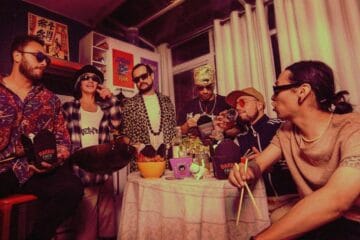 Los miembros de Katana Funk sentados en una mesa con comida asiática