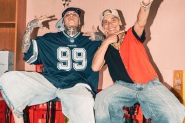Manu Chao y Santa Fe Klan sentados en unos bancos