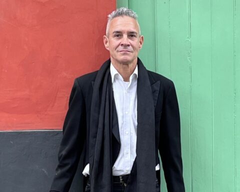 Michel Lovón parado frente a un muro de colores