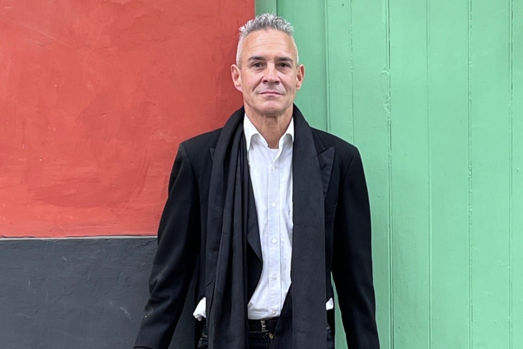 Michel Lovón parado frente a un muro de colores