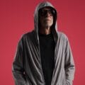 Miki González con una sudadera y fondo rojo