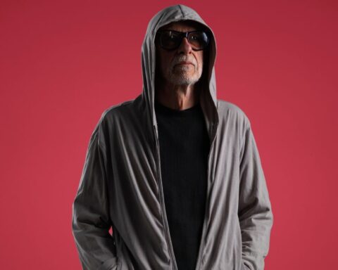 Miki González con una sudadera y fondo rojo