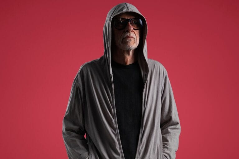 Miki González con una sudadera y fondo rojo