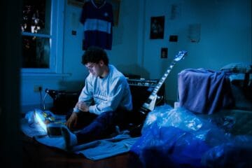 Punto y Pacífico en su habitación con su laptop y su guitarra