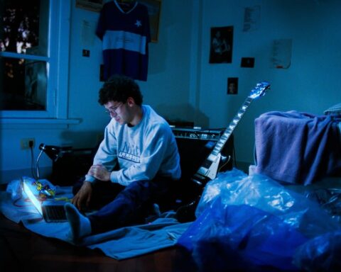 Punto y Pacífico en su habitación con su laptop y su guitarra