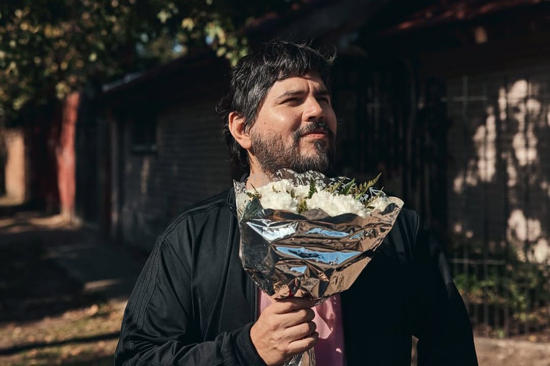 Santiago Motorizado sosteniendo un ramo de flores