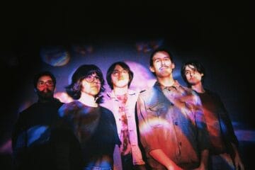 Sueño Púrpura posando con una proyección sobre sus prendas