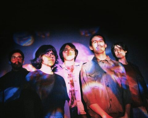 Sueño Púrpura posando con una proyección sobre sus prendas