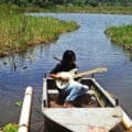 Wayku en un bota de la Amazonía con su guitarra