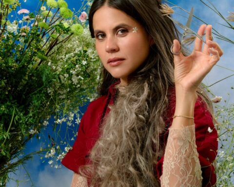 Luz Pinos con traje rojo y el brazo izquierdo alzado