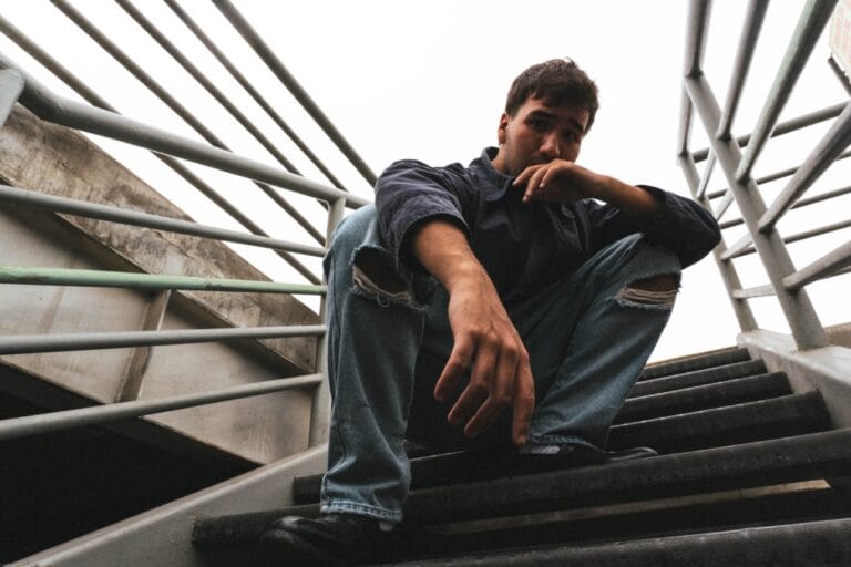 Mendo sentado sobre una escalera