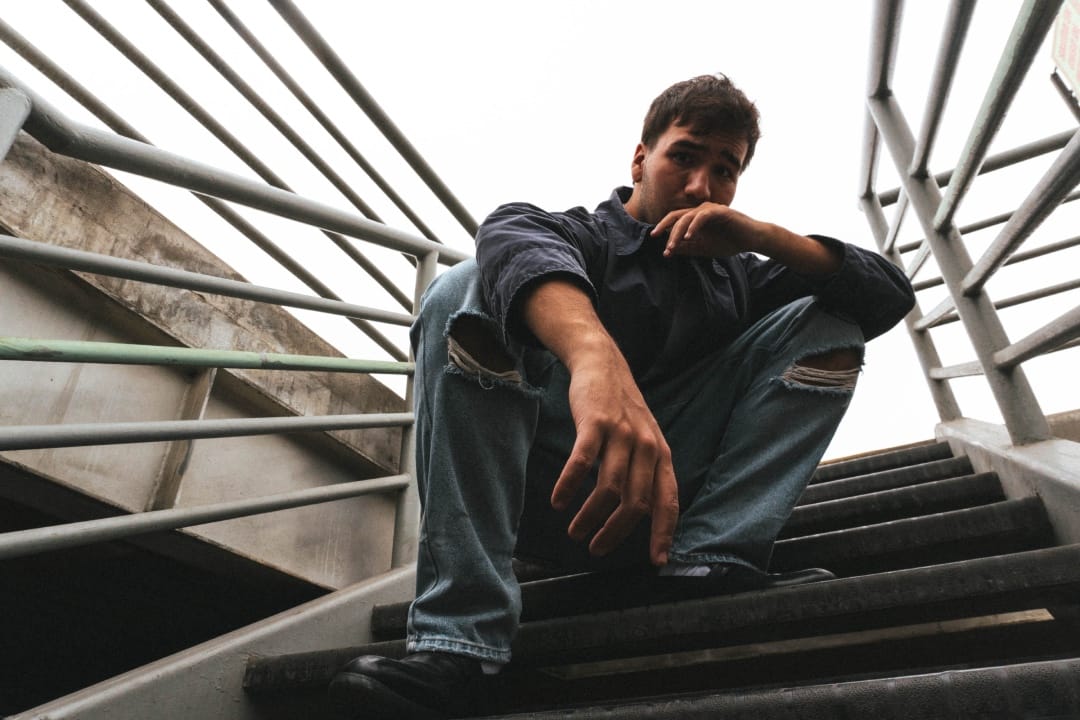 Mendo sentado sobre una escalera