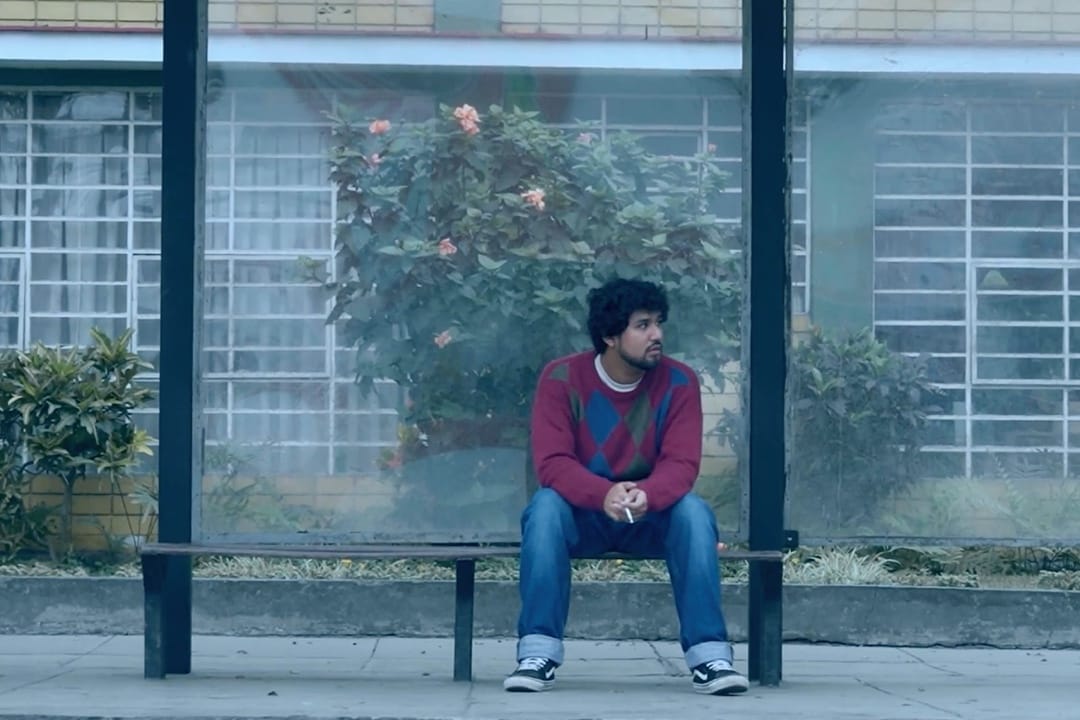 Nico es Índigo sentado en un paradero de bus