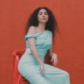 Silvana Estrada en un asiento y pared rojos