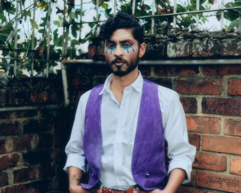 Tomás Santiago con su chaleco morado y camisa blanca