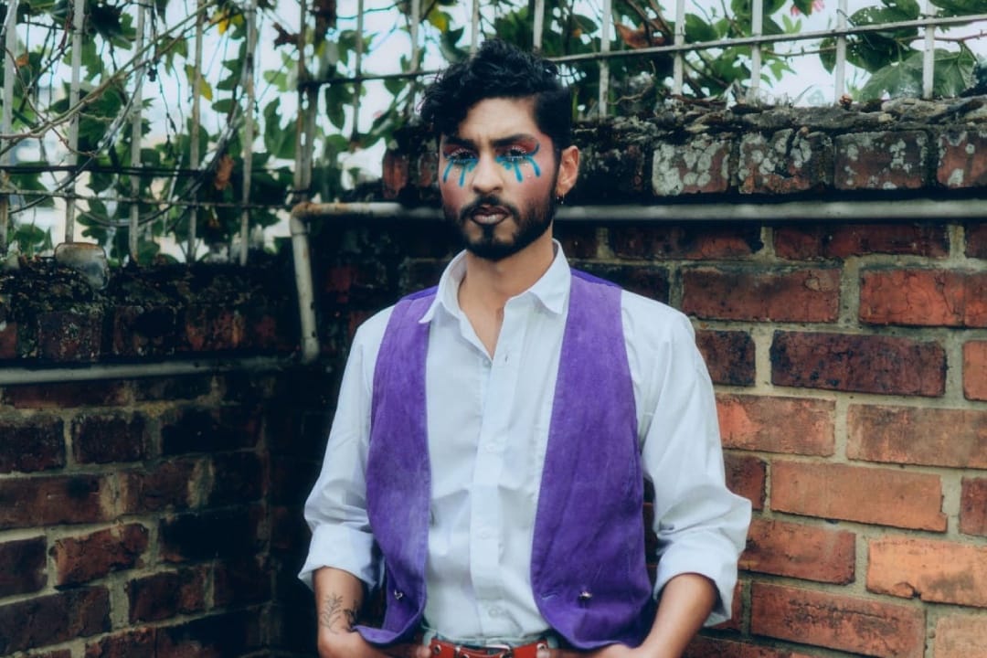 Tomás Santiago con su chaleco morado y camisa blanca