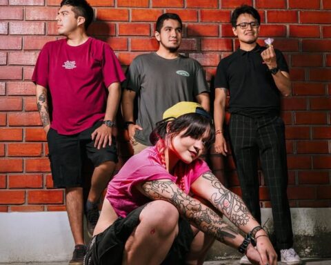 Caos en Primavera posan frente a una pared de ladrillos