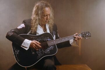 Kirk Hammett sosteniendo su guitarra Raven de Gibson