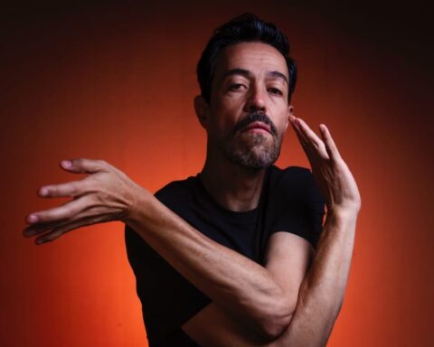 Meme del Real posando con polo negro sobre fondo rojo