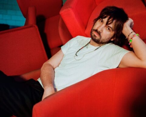 Kevin Parker de Tame Impala sobre un sofá rojo