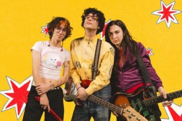 Fabricio Robles con traje amarillo y su guitarra