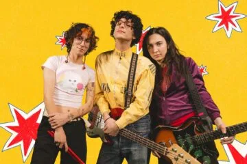 Fabricio Robles con traje amarillo y su guitarra