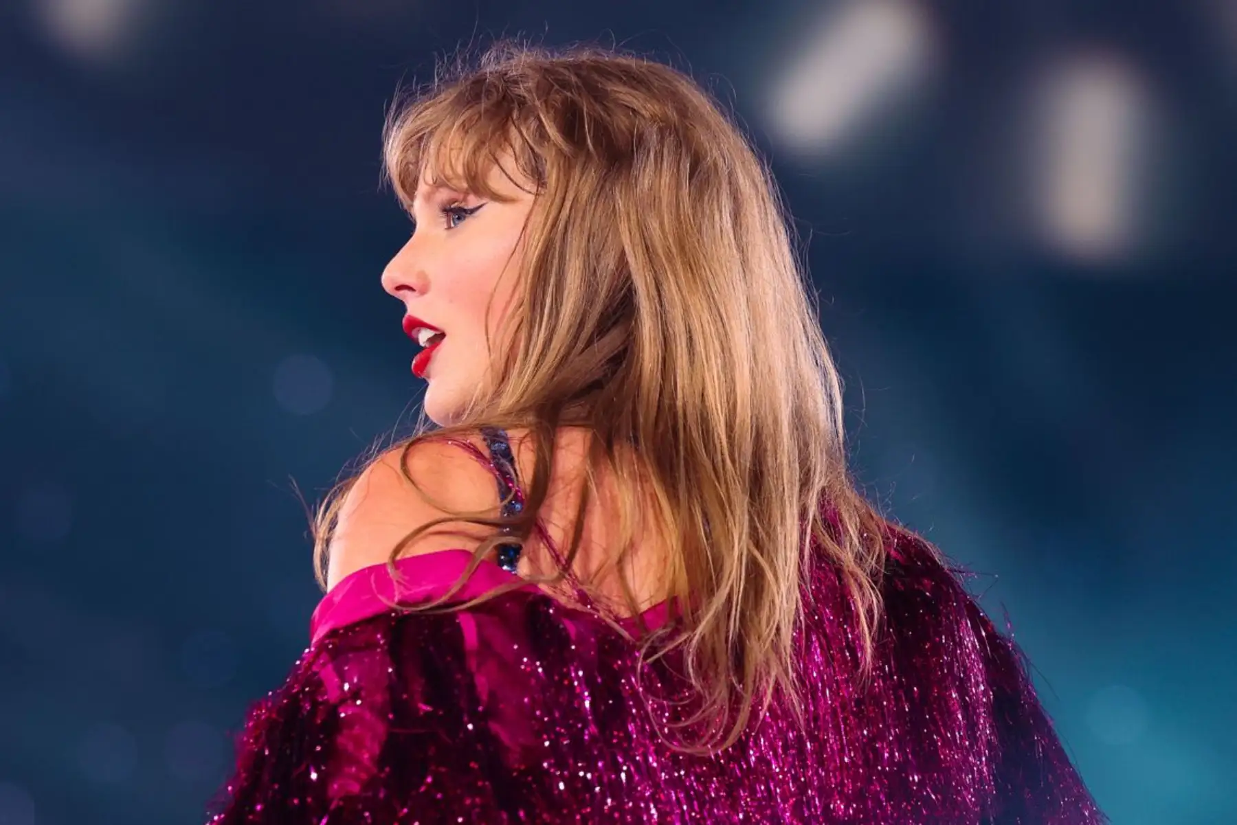 Taylor Swift de espaldas con traje magenta